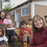 Woman looks grateful while surrounded by children.